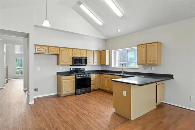 a kitchen with granite countertop a sink cabinets and stainless steel appliances