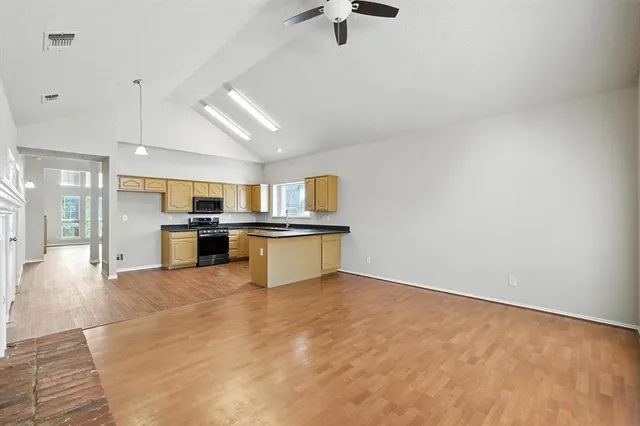 a kitchen with stainless steel appliances kitchen island granite countertop a refrigerator oven stove a sink and dishwasher