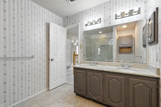 a bathroom with a granite countertop sink a mirror and a shower