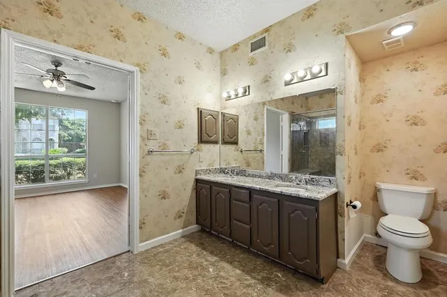 a spacious bathroom with a granite countertop sink toilet and shower