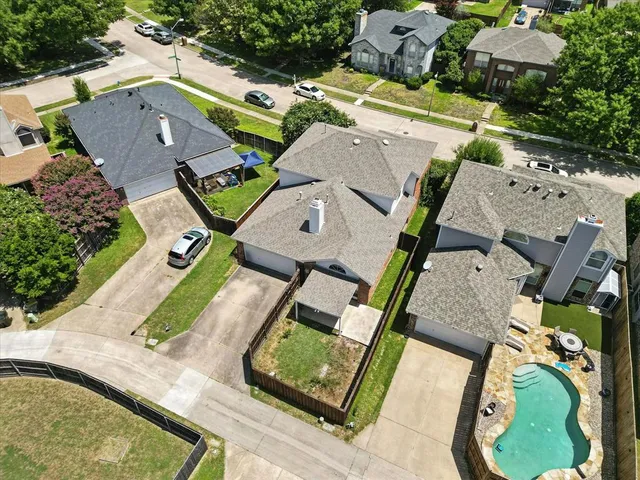 an aerial view of a house with garden space and a car park