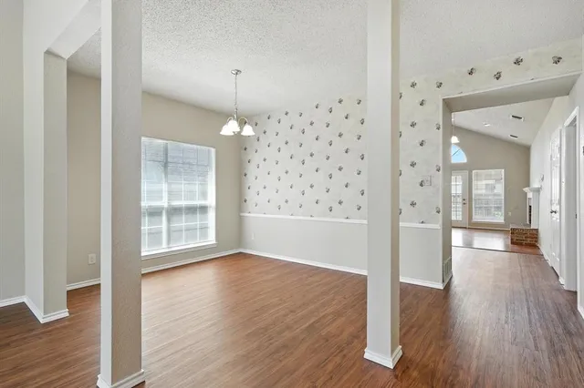 a view of a hallway with wooden floor and a living room