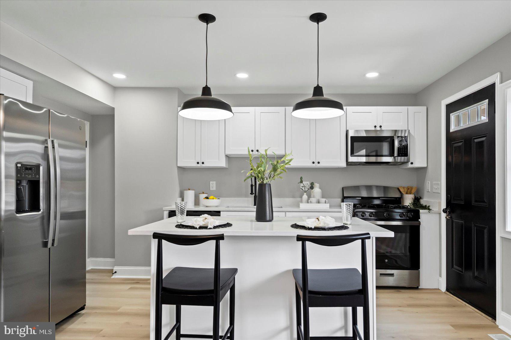 1812 Ingram Road Baltimore, MD 21239 - Photo 11 of 45 a kitchen with stainless steel appliances kitchen island granite countertop a dining table and chairs