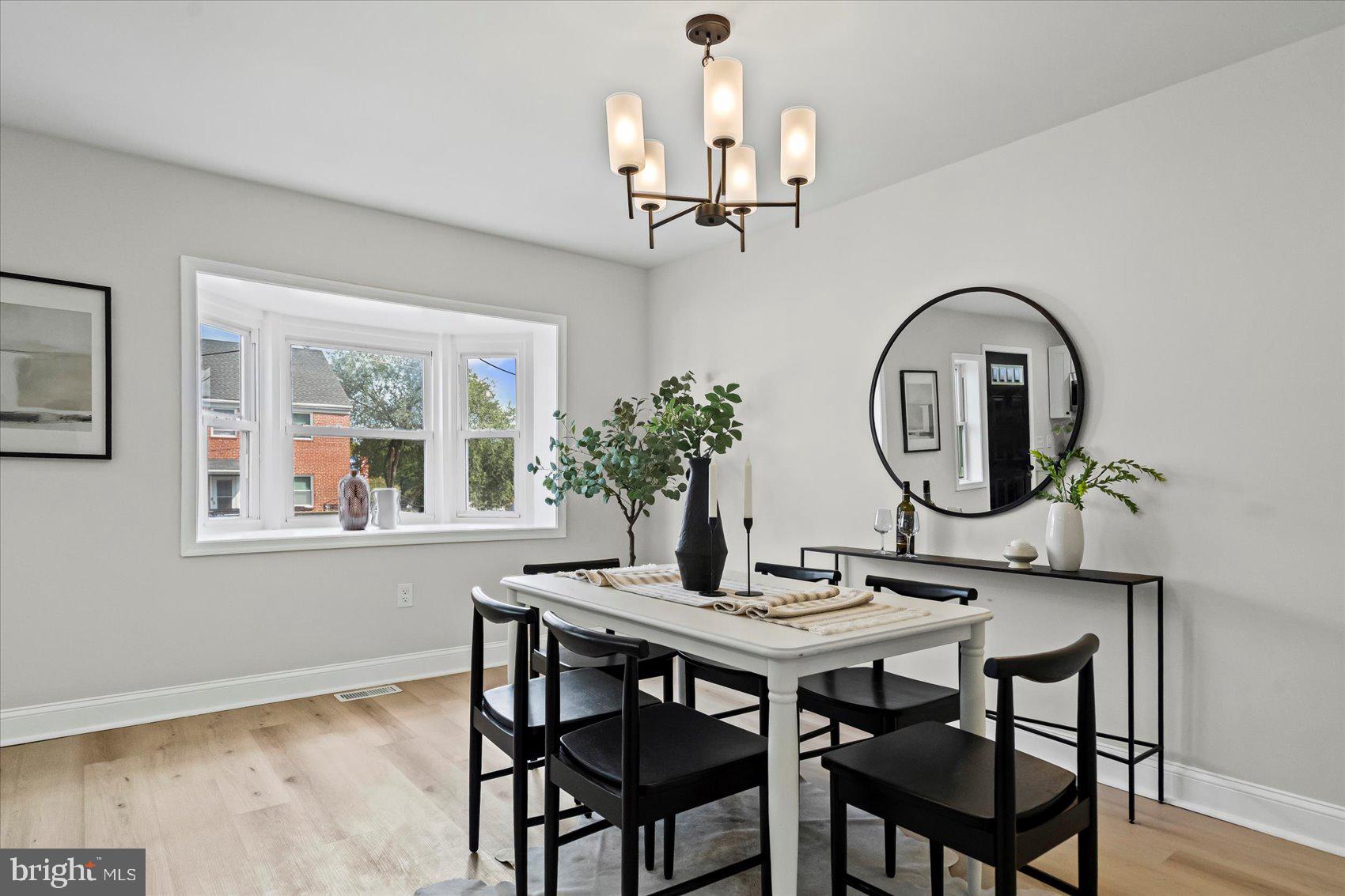 1812 Ingram Road Baltimore, MD 21239 - Photo 8 of 45 a dining room with wooden floor a chandelier a wooden table and chairs