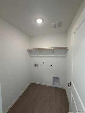 a view of an empty room with a window and a kitchen