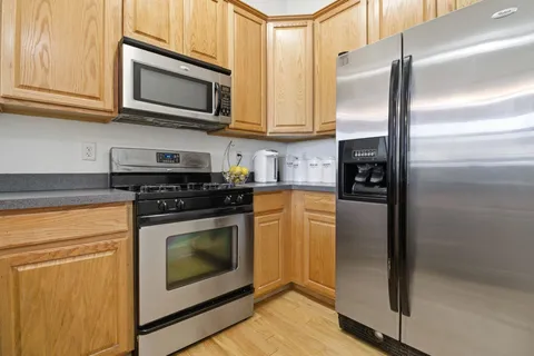 a kitchen with stainless steel appliances granite countertop a refrigerator stove and microwave
