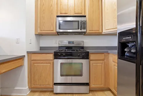 a kitchen with stainless steel appliances granite countertop a stove microwave and cabinets