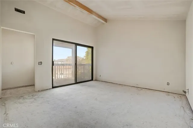 an empty room with a mirror and a glass door