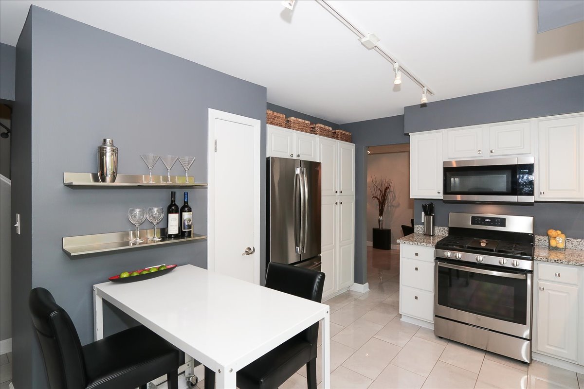 129 Regency Drive Lombard, IL 60148 - Photo 15 of 58 a kitchen with stainless steel appliances a white refrigerator a stove a microwave and cabinets