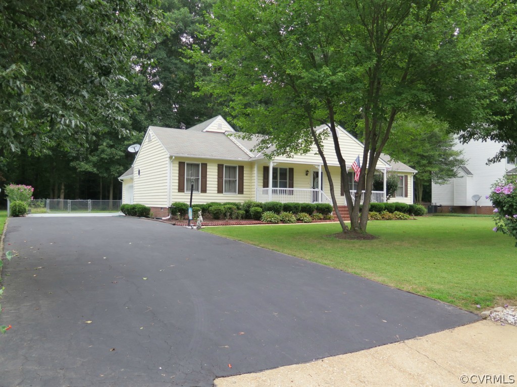 7432 Trailing Rock Road Prince George, VA 23875 - Photo 1 of 24 a front view of a house with a garden and trees