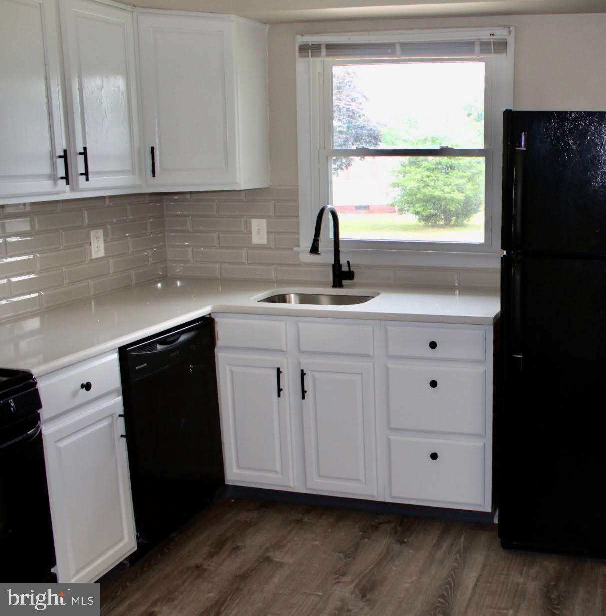 608 Whitman Street Glassboro, NJ 08028 - Photo 4 of 8 a kitchen with white cabinets and a sink