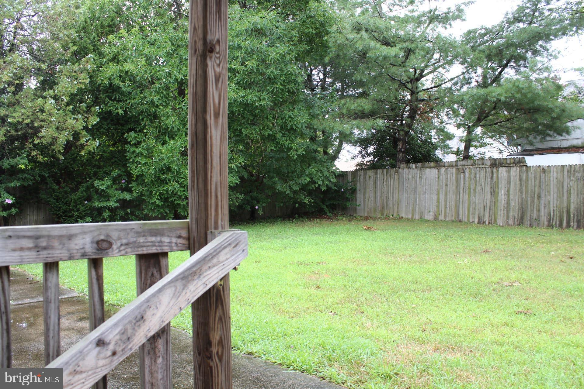 608 Whitman Street Glassboro, NJ 08028 - Photo 8 of 8 a view of a backyard with a trees and wooden fence