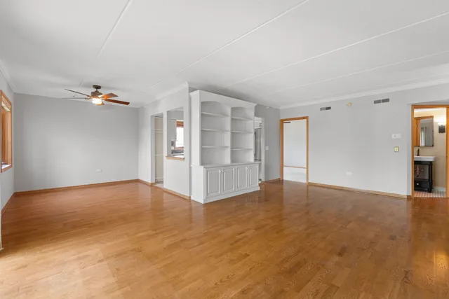 a view of an empty room with wooden floor and a cabinet