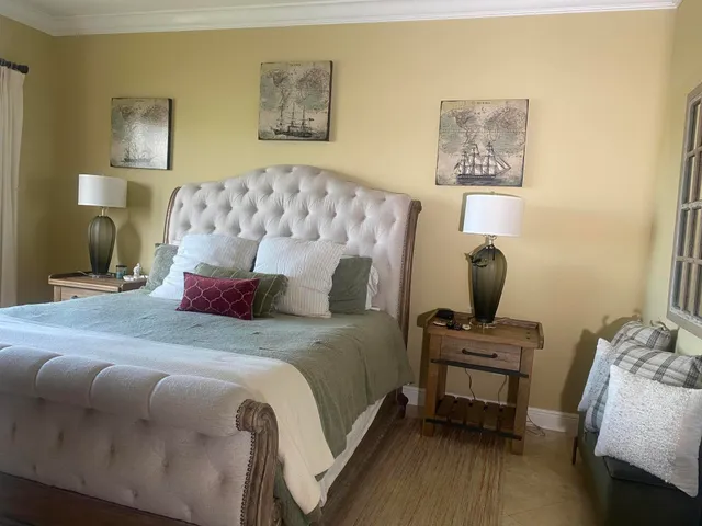 a bedroom with bed and a painting on the wall