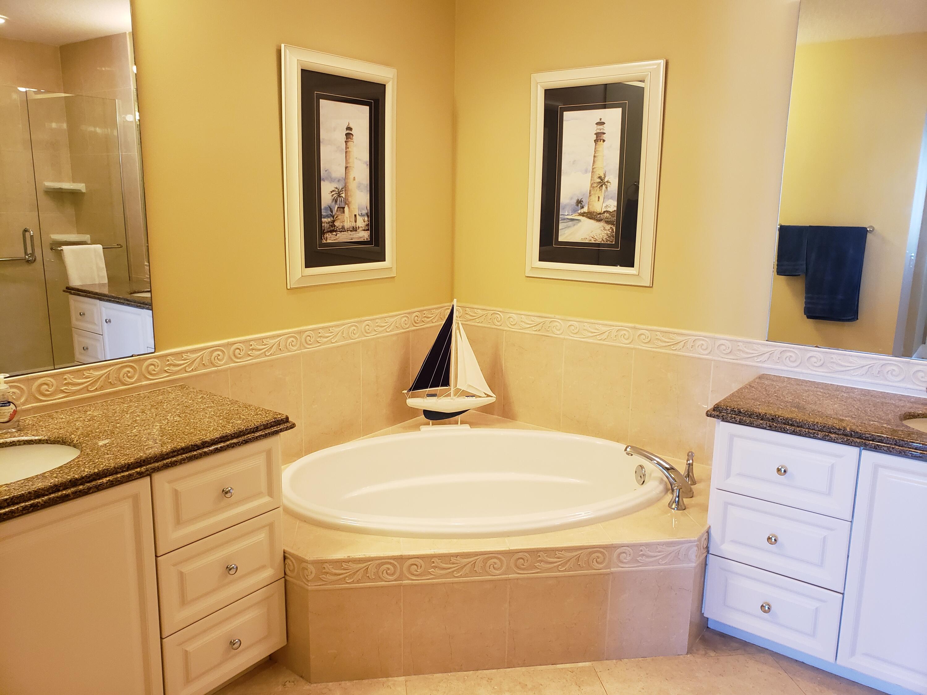 14 Harbour Isle Drive West, Unit 106 Fort Pierce, FL 34949 - Photo 16 of 23 a bathroom with a granite countertop sink a tub and a mirror