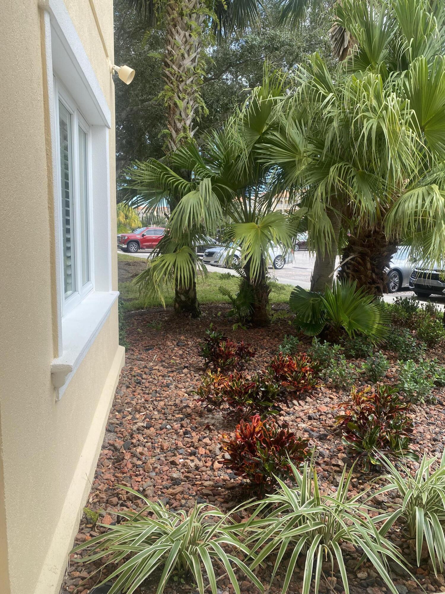 14 Harbour Isle Drive West, Unit 106 Fort Pierce, FL 34949 - Photo 18 of 23 a backyard of a house with a garden and outdoor seating
