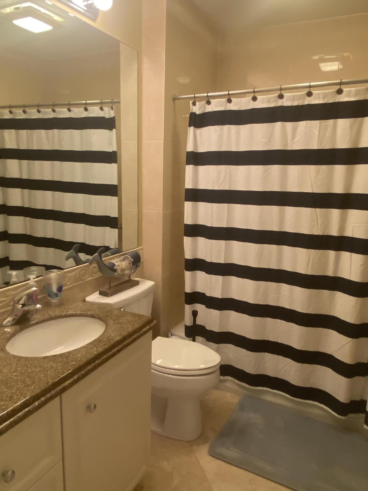 14 Harbour Isle Drive West, Unit 106 Fort Pierce, FL 34949 - Photo 19 of 23 a bathroom with a sink a toilet and shower