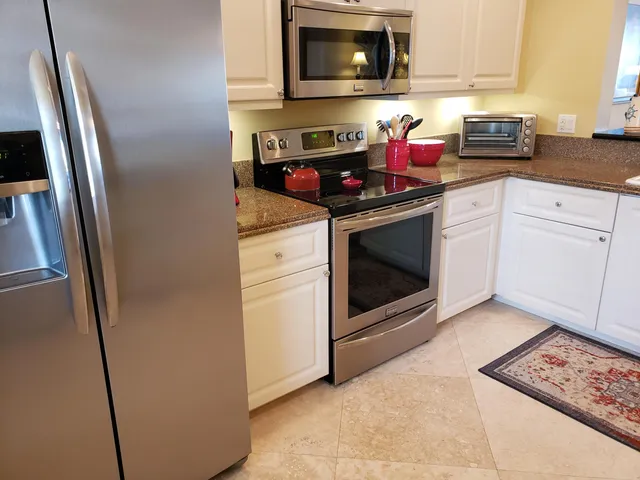 a kitchen with stainless steel appliances granite countertop a stove microwave and sink