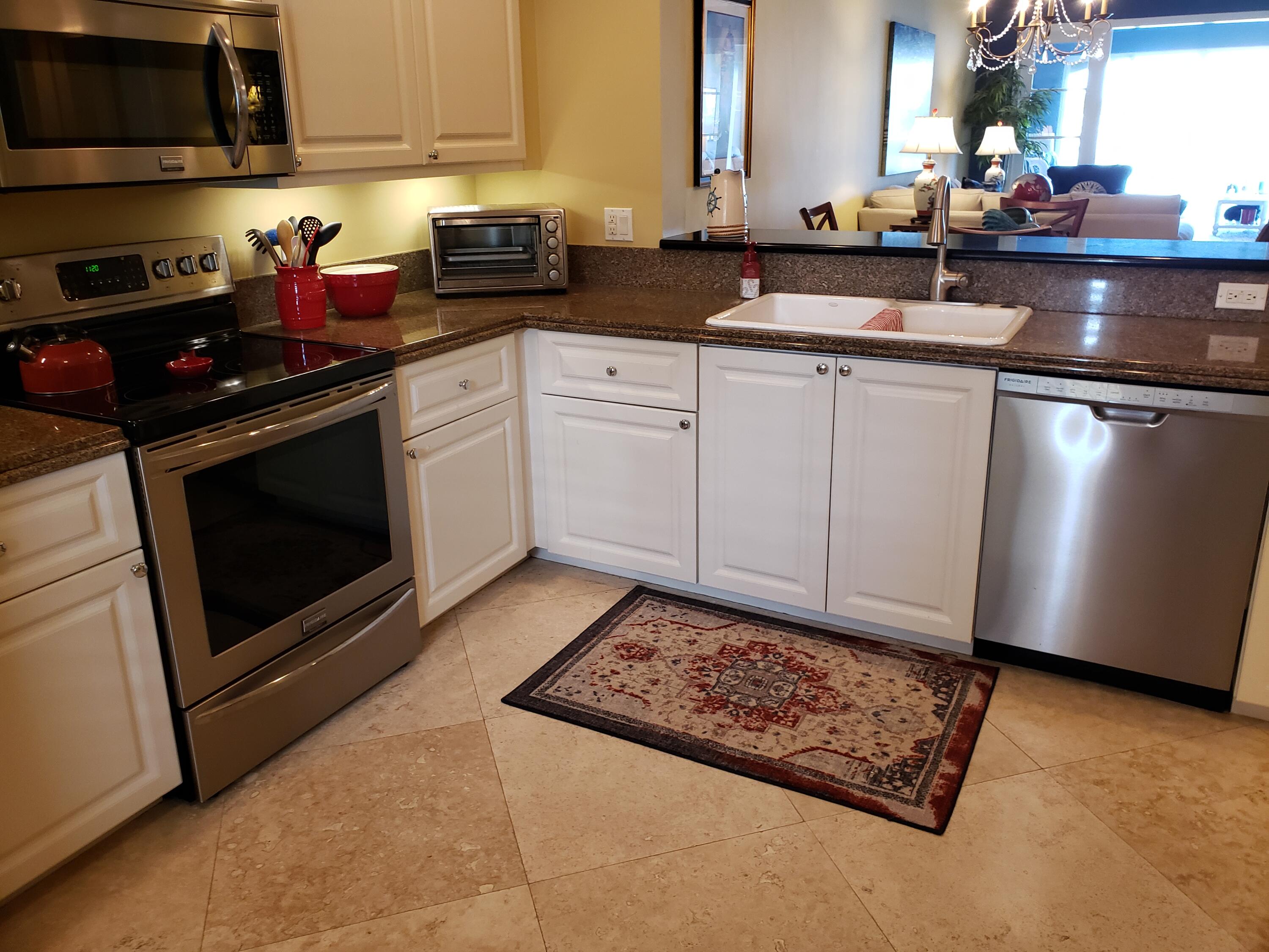 14 Harbour Isle Drive West, Unit 106 Fort Pierce, FL 34949 - Photo 5 of 23 a kitchen with stainless steel appliances a sink a stove a microwave and cabinets