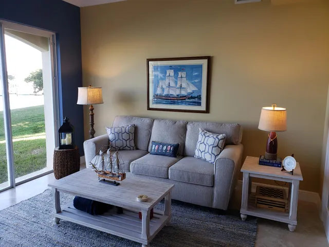 a living room with furniture a lamp and a floor to ceiling window