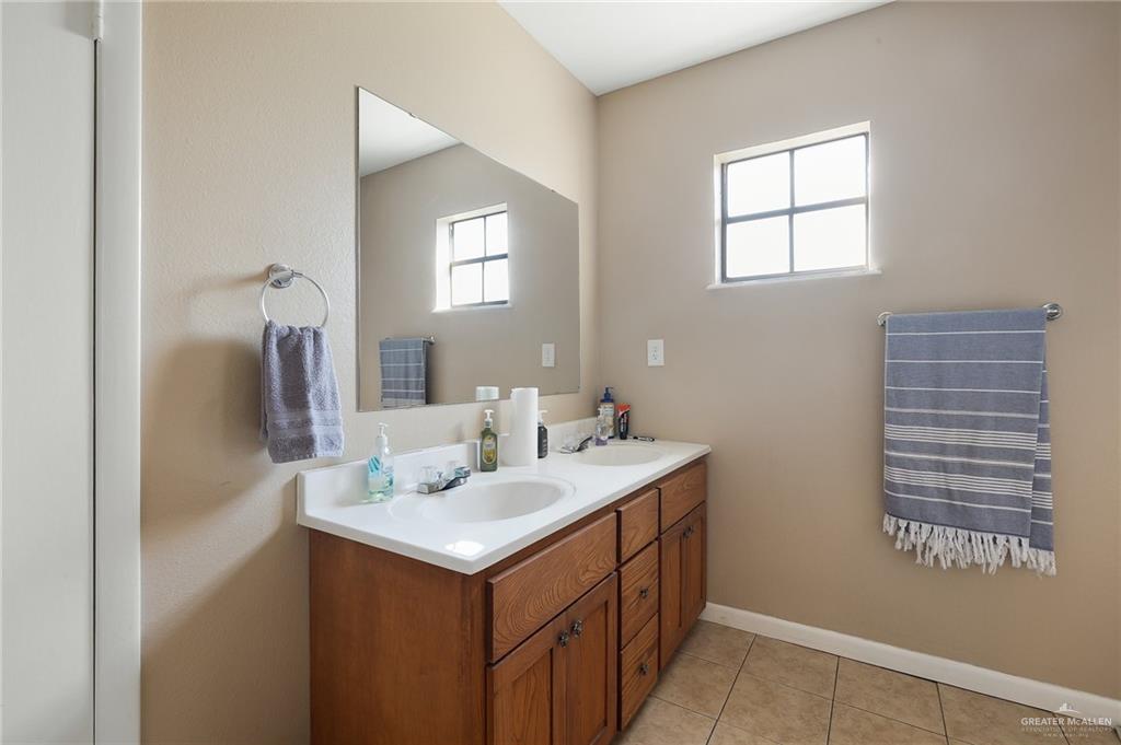 3721 North Veterans Boulevard Pharr, TX 78577 - Photo 12 of 18 Full bath with baseboards, double vanity, a sink, and tile patterned flooring