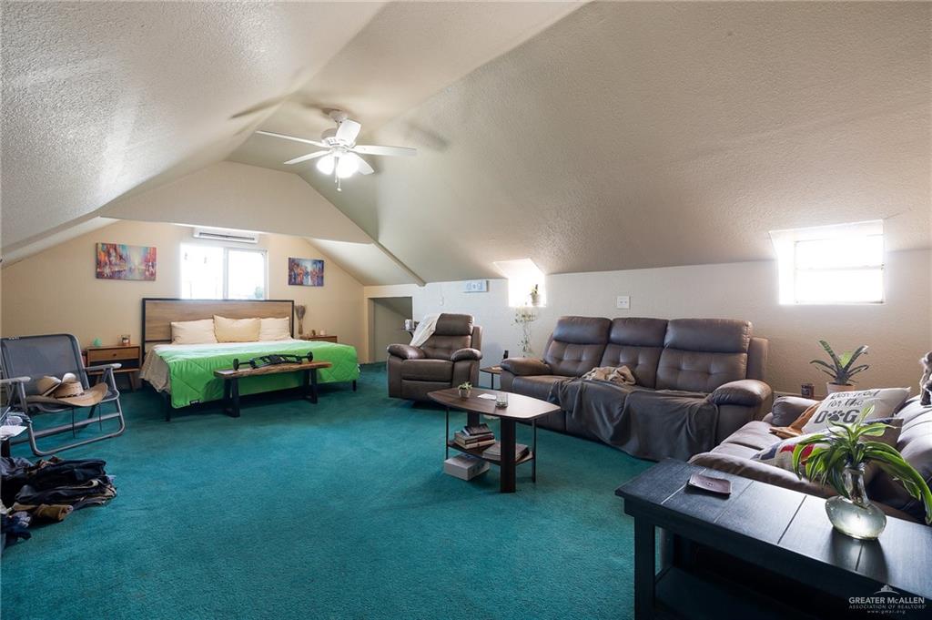 3721 North Veterans Boulevard Pharr, TX 78577 - Photo 14 of 18 Living area featuring carpet floors, a textured ceiling, lofted ceiling, visible vents, and ceiling fan