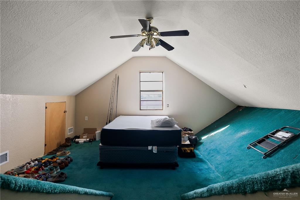 3721 North Veterans Boulevard Pharr, TX 78577 - Photo 15 of 18 Bedroom with vaulted ceiling, carpet flooring, a ceiling fan, a textured ceiling, and visible vents