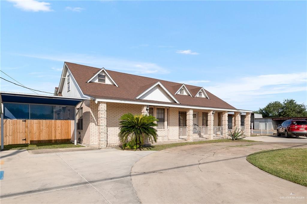 3721 North Veterans Boulevard Pharr, TX 78577 - Photo 2 of 18 View of front of home featuring fence, covered porch, brick siding, driveway, and a shingled roof