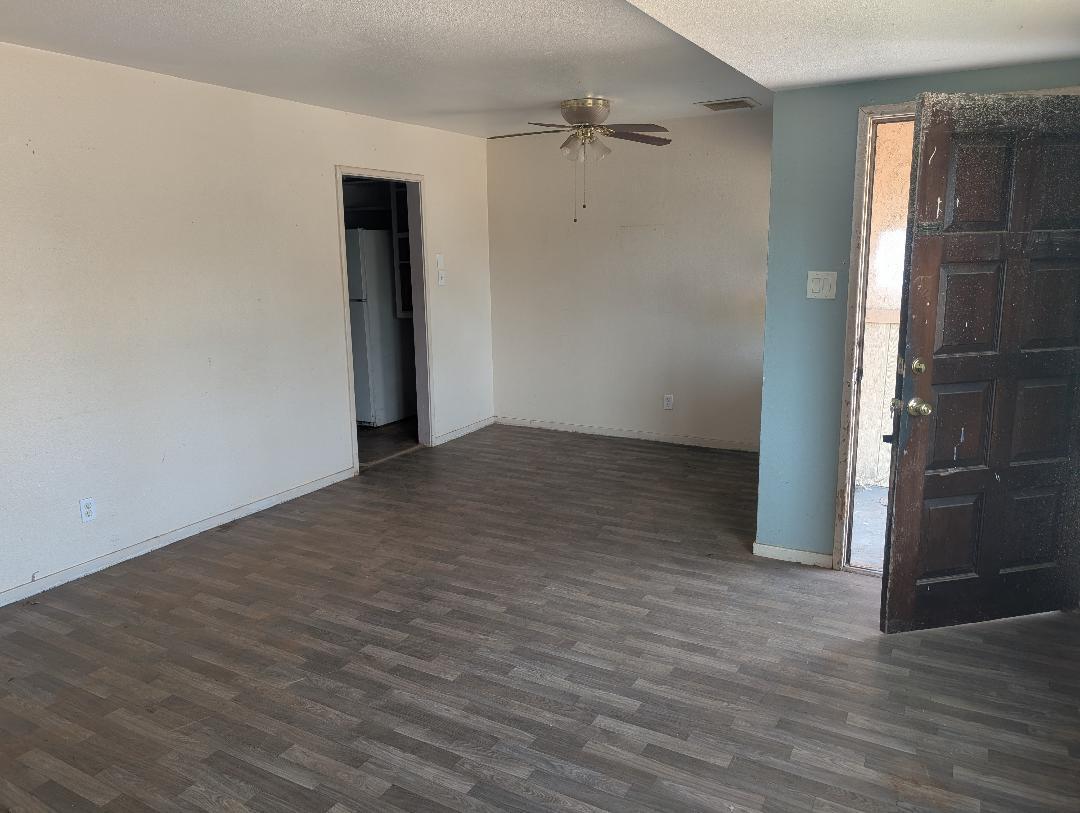 1118 4th Street Redding, CA 96002 - Photo 3 of 16 a view of an empty room with wooden floor and a window