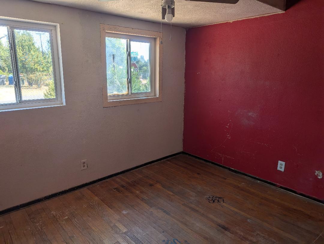 1118 4th Street Redding, CA 96002 - Photo 8 of 16 an empty room with wooden floor and windows