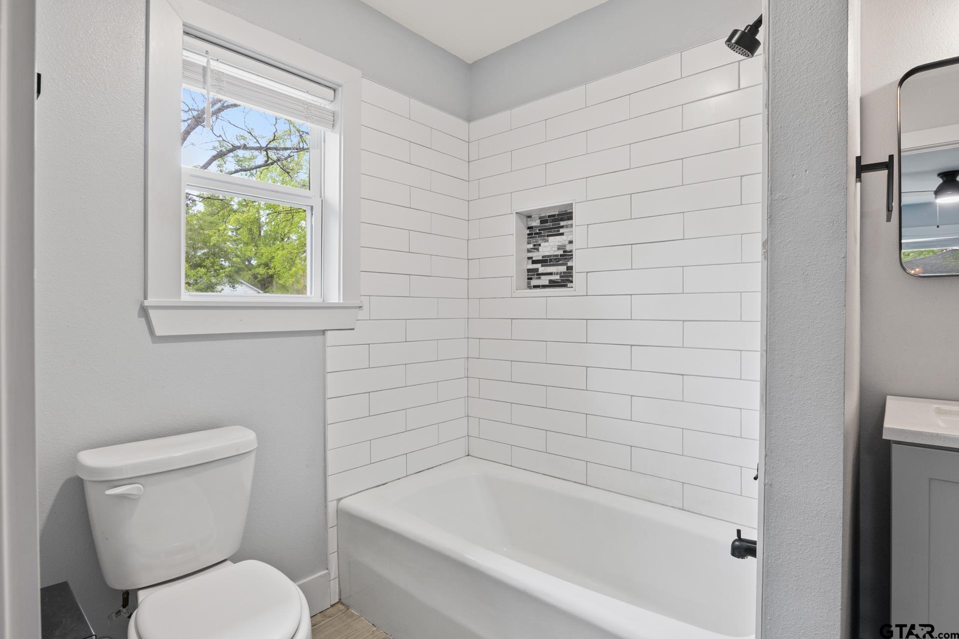 802 Quitman Street Pittsburg, TX 75686 - Photo 16 of 24 a white toilet sitting next to a bath tub