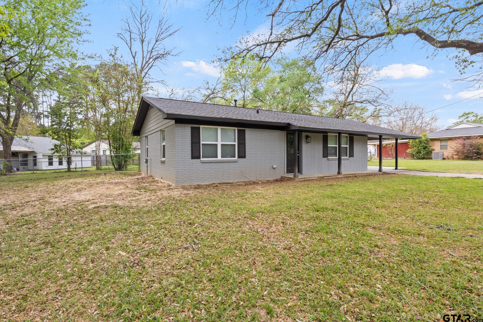 802 Quitman Street Pittsburg, TX 75686 - Photo 2 of 24 a front view of a house with a garden