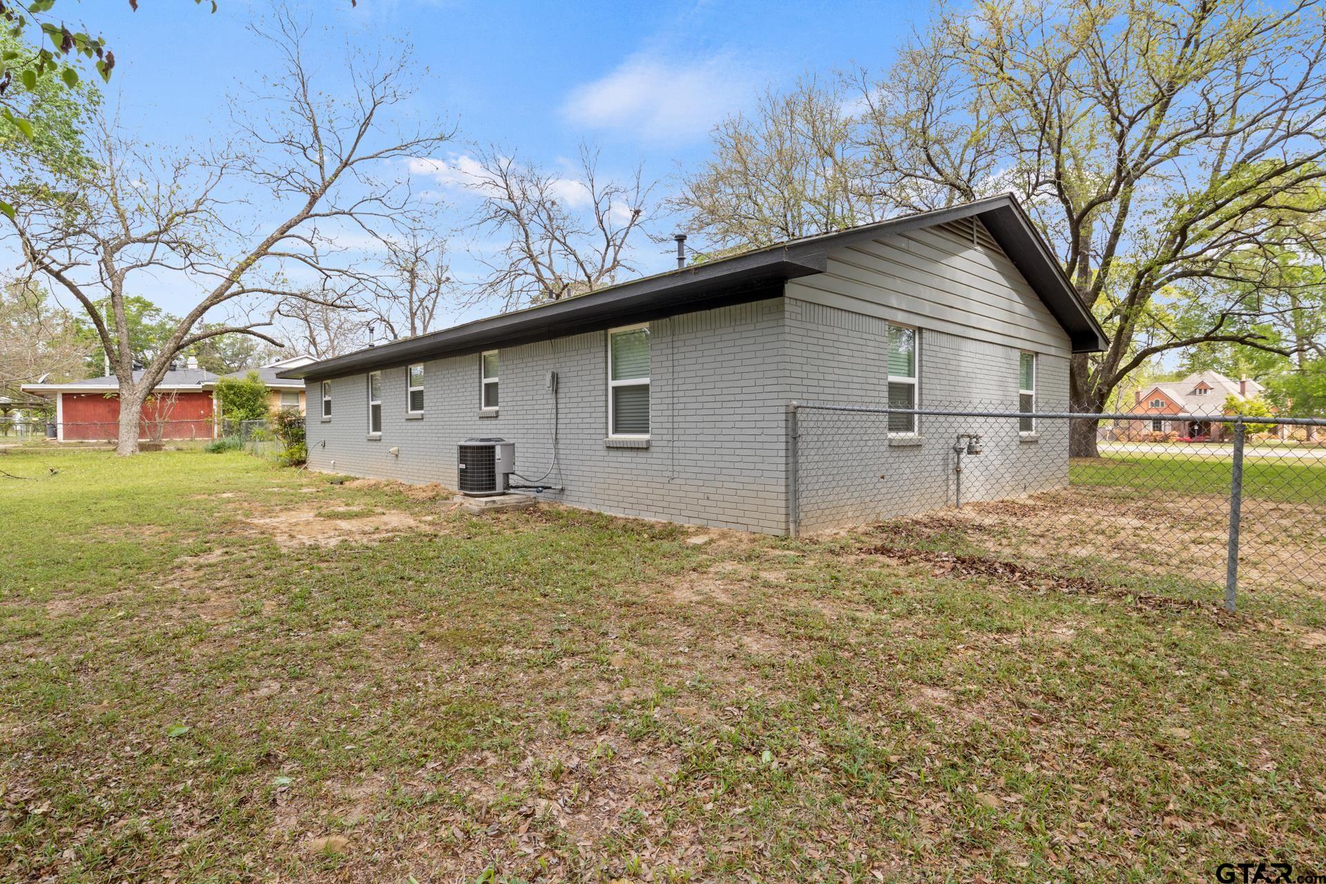 802 Quitman Street Pittsburg, TX 75686 - Photo 24 of 24 a house with trees in the background