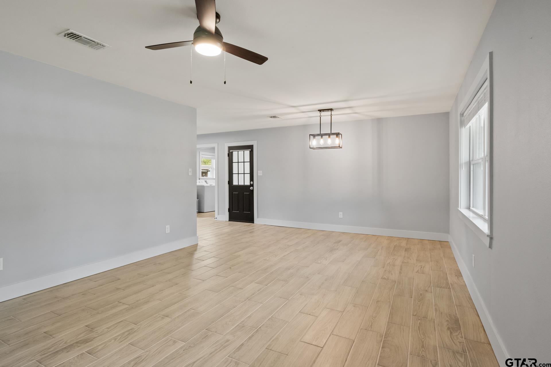802 Quitman Street Pittsburg, TX 75686 - Photo 4 of 24 wooden floor in an empty room with a window