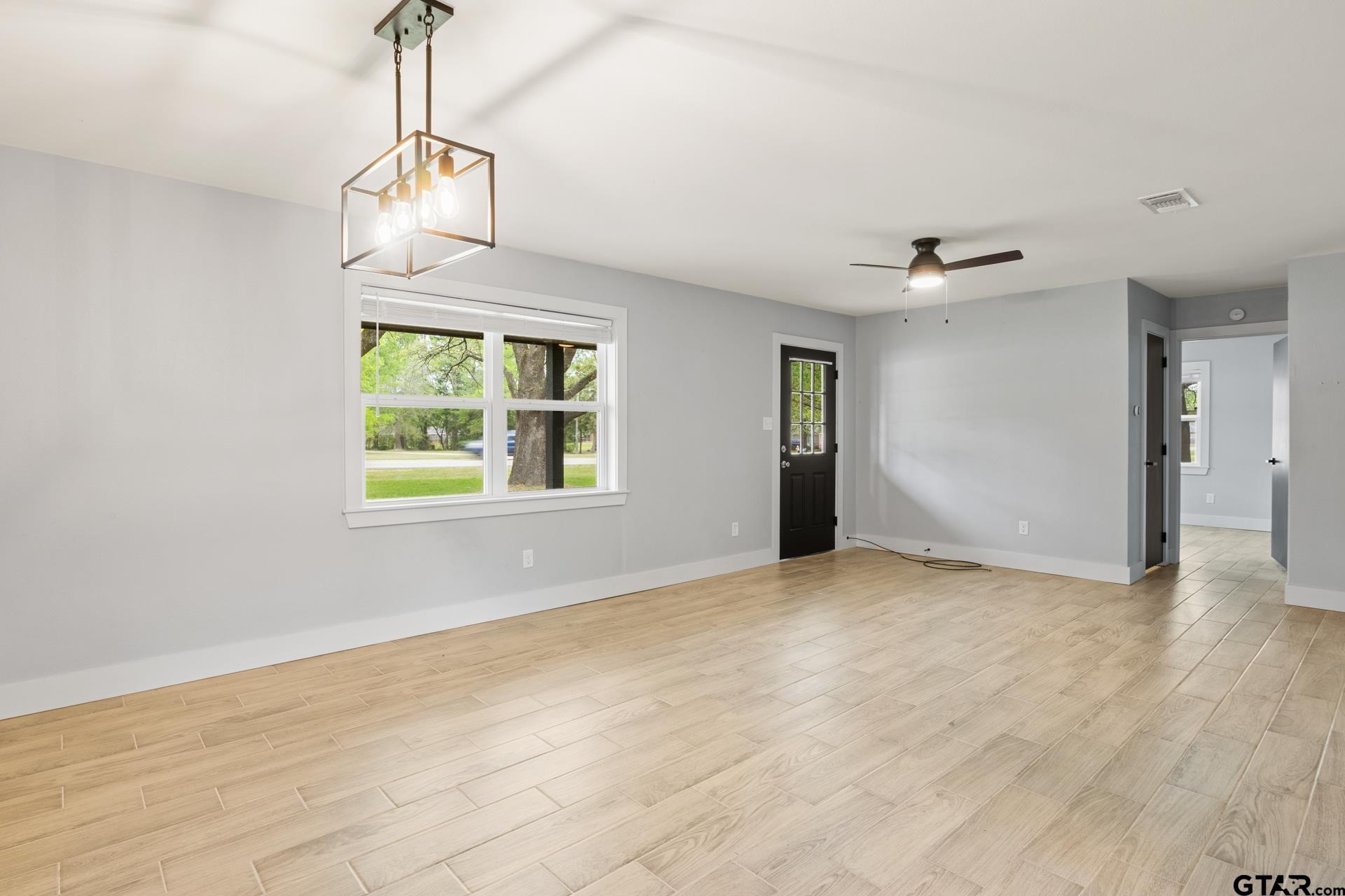 802 Quitman Street Pittsburg, TX 75686 - Photo 6 of 24 a view of an empty room with window and chandelier fan