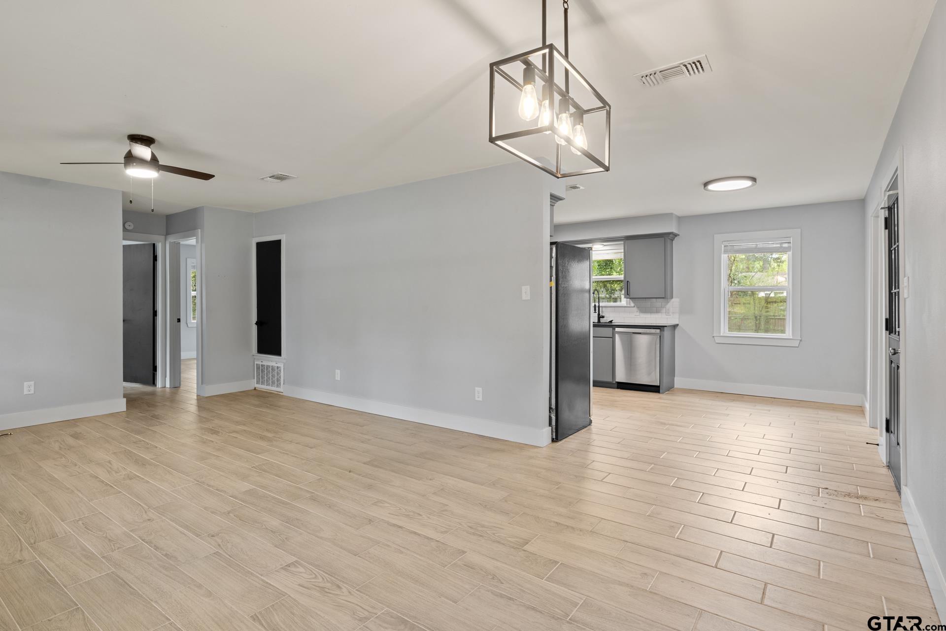 802 Quitman Street Pittsburg, TX 75686 - Photo 7 of 24 a view of an empty room with wooden floor and a window