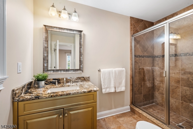 5 Rigger Court Hillsborough, NJ 08844 - Photo 28 of 42 a bathroom with a granite countertop sink a mirror and a shower
