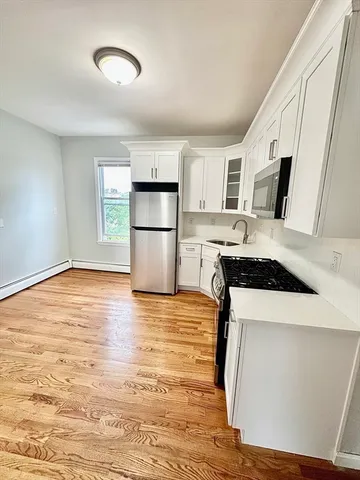 a kitchen with kitchen island a stove a sink and a refrigerator