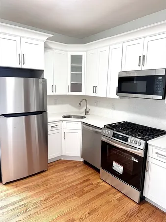 a kitchen with granite countertop a refrigerator stove and microwave