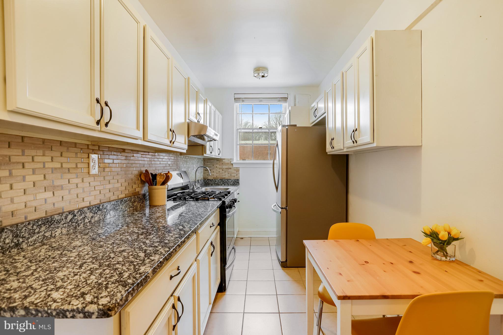 1446 Tuckerman Street Northwest, Unit 307 Washington, DC 20011 - Photo 1 of 18 a kitchen with granite countertop a sink a stove and a refrigerator