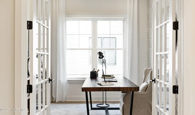 a view of a workspace with furniture and a window