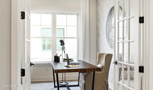 a view of a workspace with furniture and a window