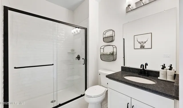 a bathroom with a granite countertop sink a toilet and a shower