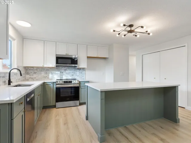 a kitchen with kitchen island granite countertop a sink cabinets and wooden floor