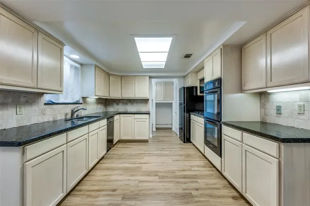 a kitchen with granite countertop stainless steel appliances and wooden cabinets