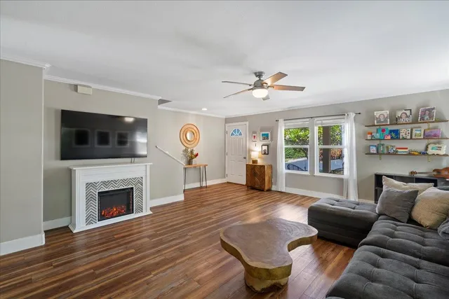 a living room with furniture a wooden floor and a window