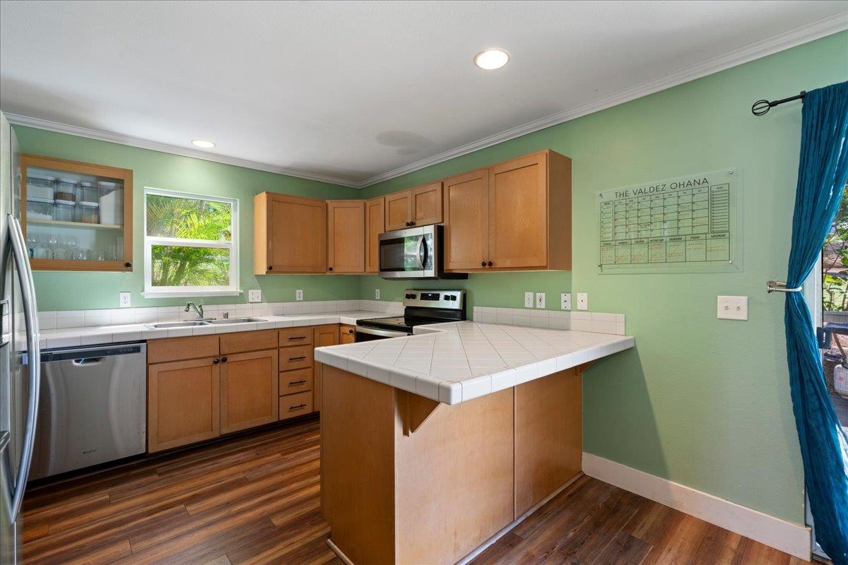 2740 Liholani Street, Unit 10 Pukalani, HI 96768 - Photo 18 of 50 a kitchen with a sink stove and cabinets