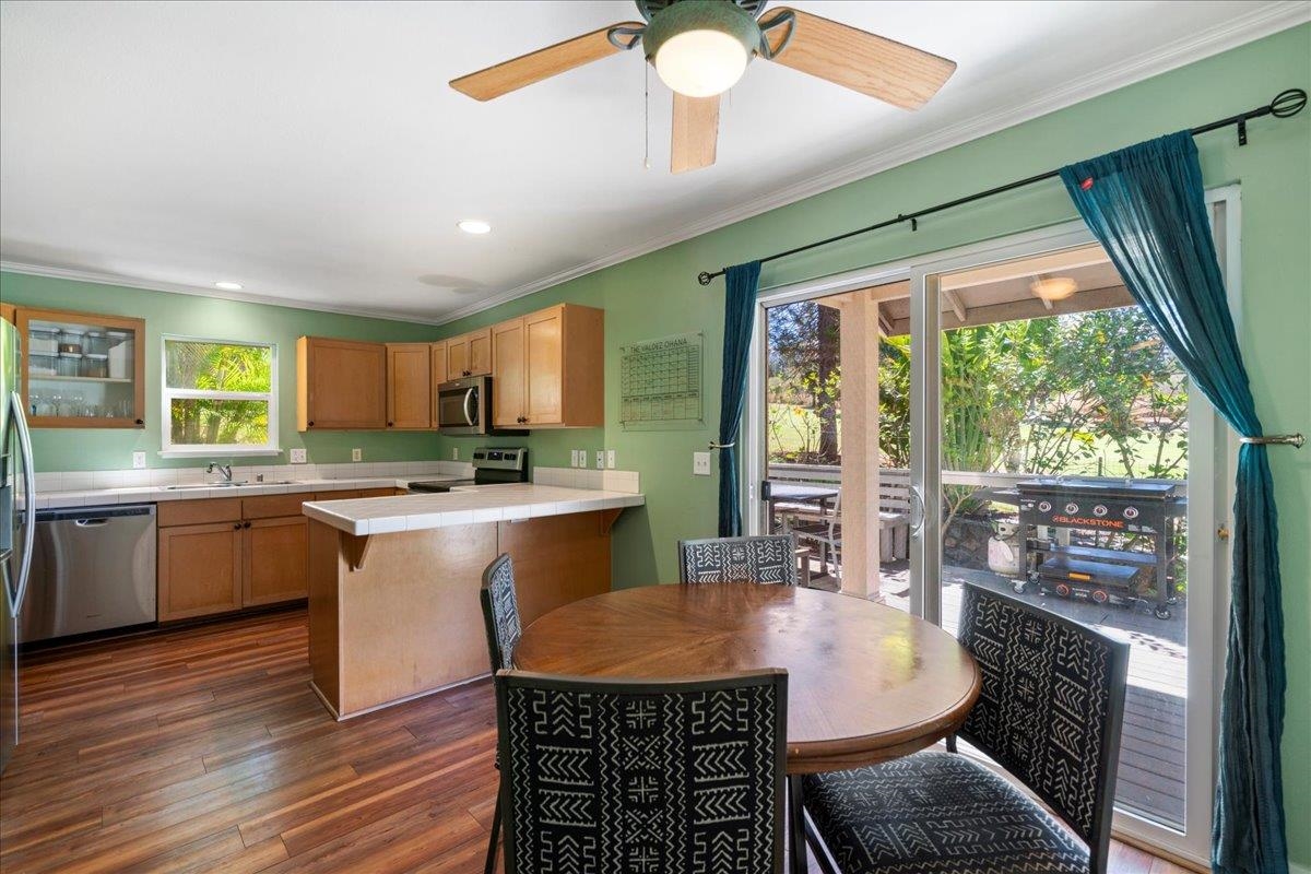 2740 Liholani Street, Unit 10 Pukalani, HI 96768 - Photo 24 of 50 a kitchen with granite countertop a stove a sink a dining table and chairs with wooden floor