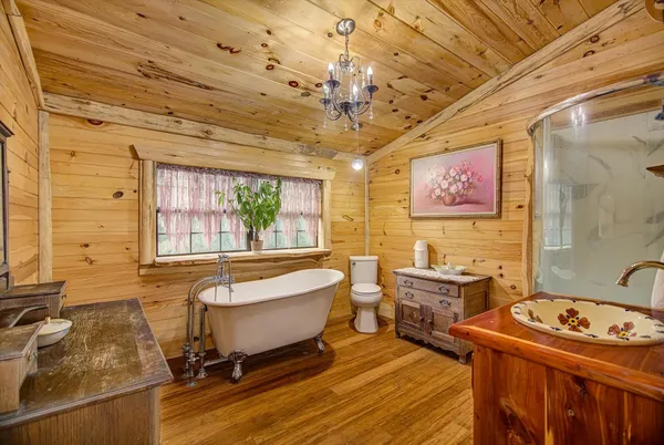 a spacious bathroom with a tub a sink and mirror