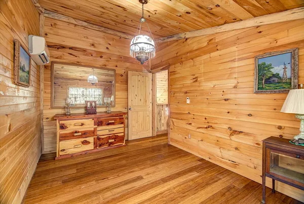 a view of a hallway with wooden floor and a ceiling fan